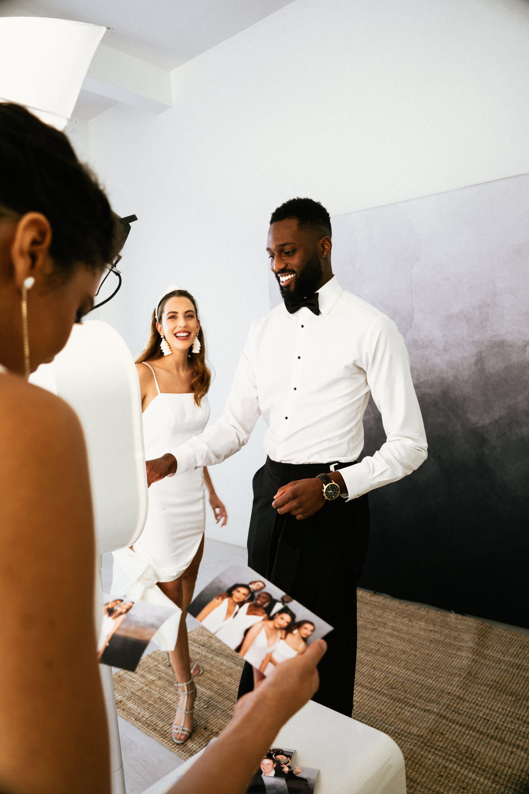 Bride and groom reviewing their freshly printed photo booth strips