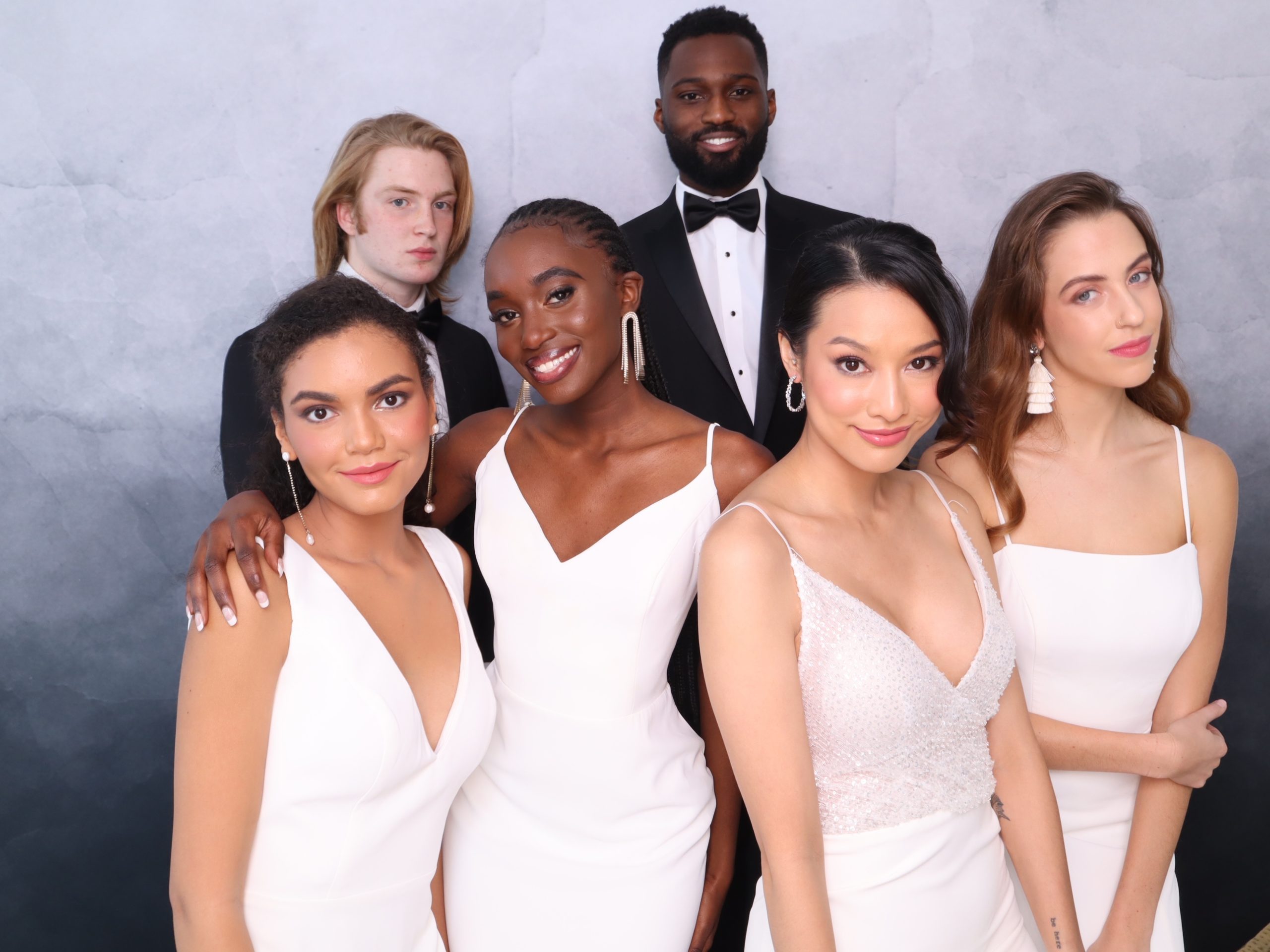 Wedding party posed together at the Meridian Moments photo booth backdrop